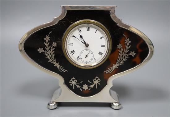 A George V silver and tortoiseshell pique mounted timepiece, S.W. Goode & Co, Chester, 1920, 10cm and a similar toilet set(a.f.)